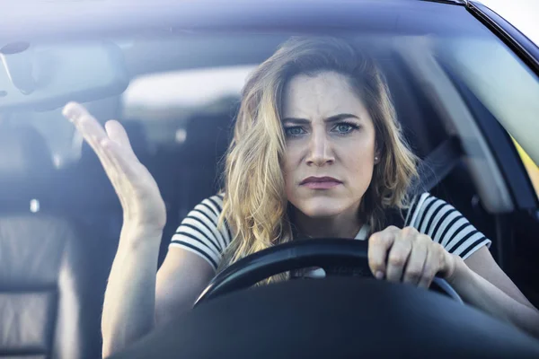 Angry woman driving a car. — Stock Photo, Image