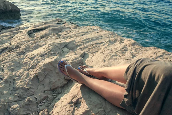 Piedi femminili sulla riva rocciosa di pietra del mare . — Foto Stock