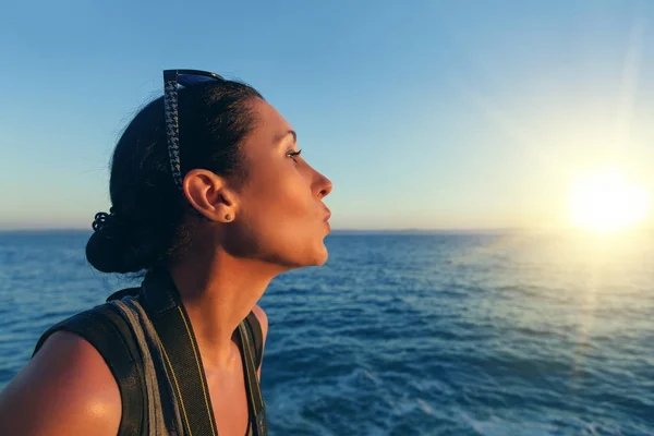 Ritratto di donna primo piano sullo sfondo del mare e tramonto in una serata estiva . — Foto Stock