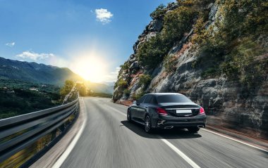 Siyah araba güneş yüksek hızlı bir yolu boyunca acele.