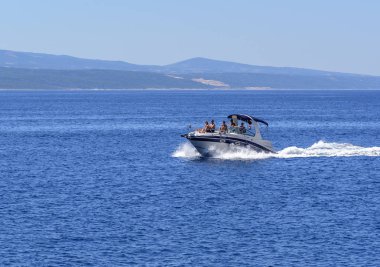 Teknenin istirahat kişi ile hızlı bir şekilde dalgalar deniz taşınıyor.