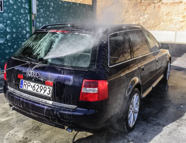 Lavado a alta presión del coche al aire libre. Coche Audi A6 en una lavadora de alta presión . — Foto de Stock