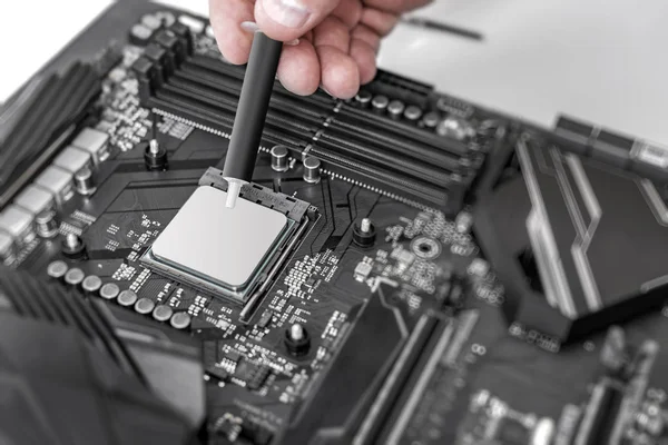 Ingeniero aplicando pasta térmica en el chip de placa de ordenador cpu . —  Fotos de Stock