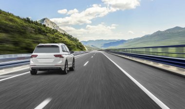 Güneş yüksek hızlı bir yolu boyunca acele bir beyaz araba.