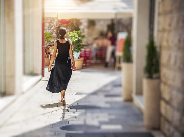 Giovane donna sulla strada della città vecchia in un vestito in una giornata di sole . — Foto Stock