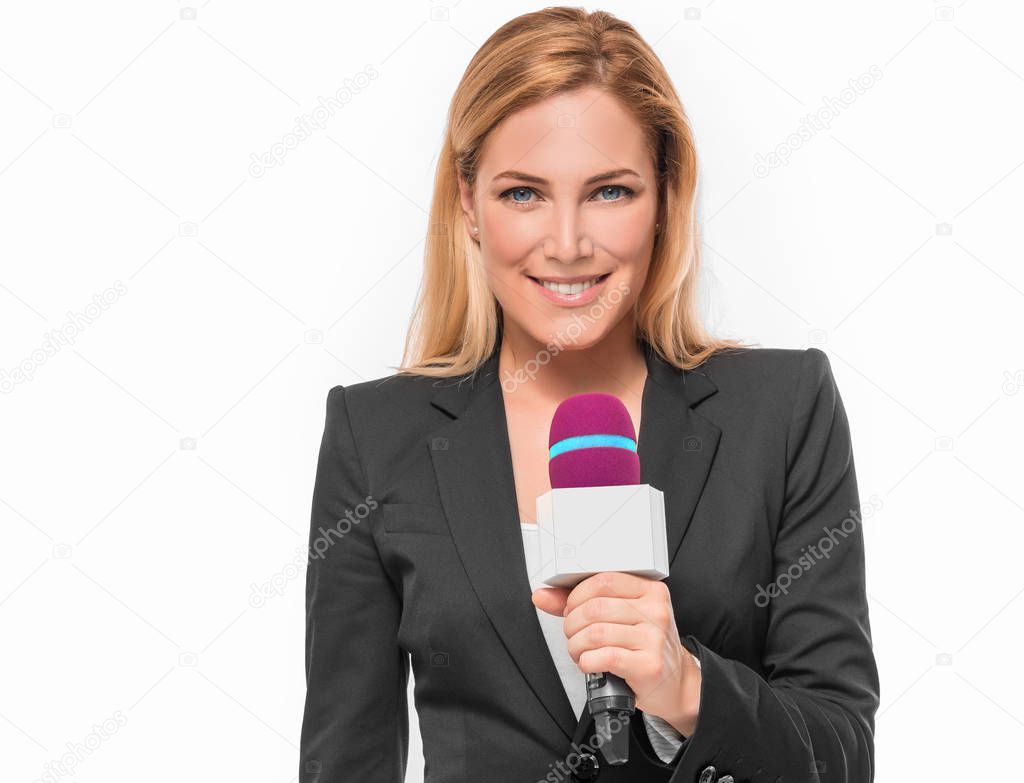 Attractive blonde TV presenter holding a microphone and points to an object.