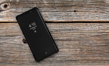 Samsung Galaxy Not 9 smartphone geliştirdi ve Samsung Electronics tarafından pazarlanan bir ahşap zemin üzerine.