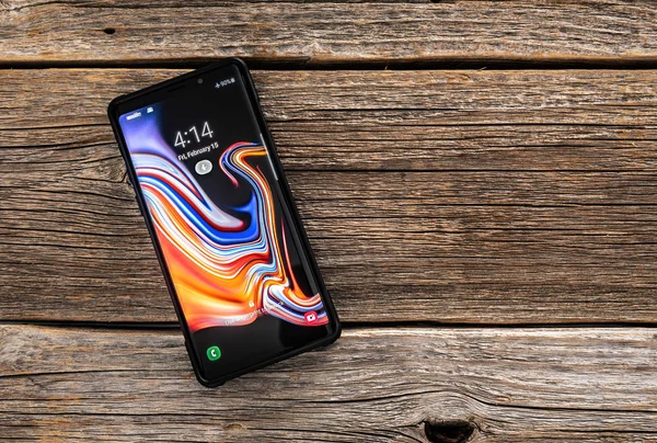 Smartfon Samsung Galaxy Uwaga 9 na podłoże drewniane, opracowane i sprzedawane przez firmę Samsung Electronics. — Zdjęcie stockowe