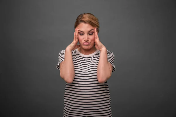 Een vrouw vindt haar hoofd te houden of heeft een hoofdpijn. — Stockfoto