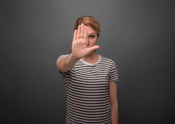 Bir kadın onun el palm öne çeker. Dur işareti. Gri bir arka plan üzerinde. — Stok fotoğraf