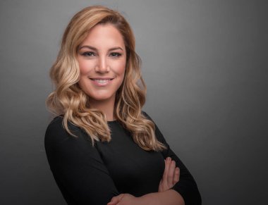 Gri bir arka planda koyu kıyafetler çekici sarışın.