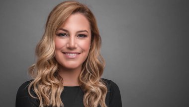 Gri bir arka planda koyu kıyafetler çekici sarışın.