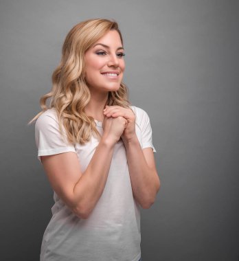 Kadın gri arka planda bir dua sırasında gibi göğsüne kollarını katlanmış.