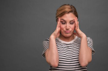 Bir kadının kafasını tutarak düşünüyor ya da bir baş ağrısı vardır.