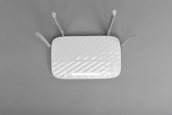 Routeur Wi-Fi moderne blanc avec quatre antennes sur fond gris . — Photo