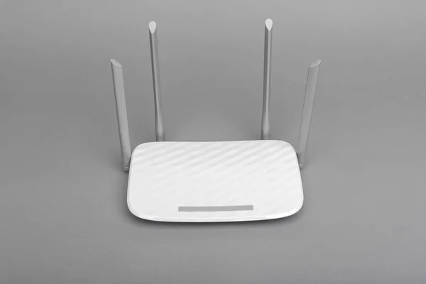 Roteador Wi-Fi moderno branco com quatro antenas em fundo cinza . — Fotografia de Stock