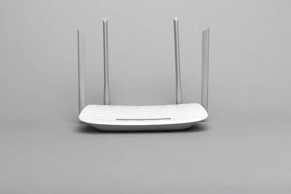 Routeur Wi-Fi moderne blanc avec quatre antennes sur fond gris . — Photo