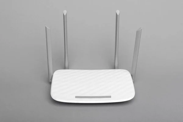 Moderní bílý Wi-Fi router se čtyřmi anténami na šedém pozadí. — Stock fotografie