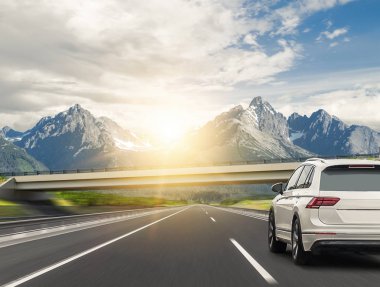 Araba bir dağ sırasının arka planında karayolu üzerinde hızlı sürücüler.