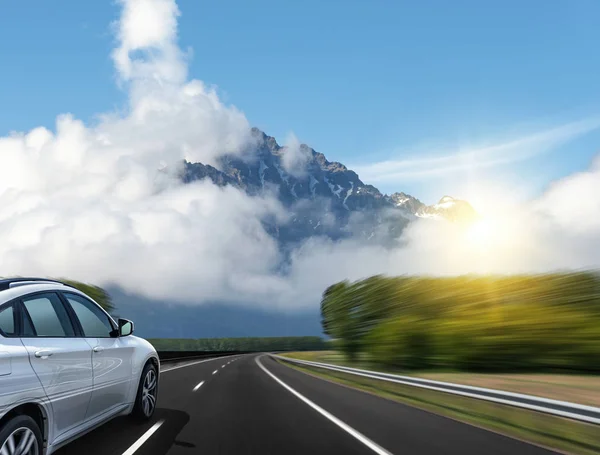 자동차는 산맥을 배경으로 고속도로에서 빠르게 운전합니다.. — 스톡 사진