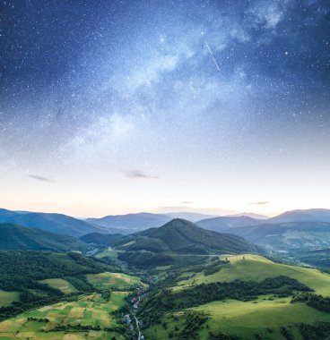 Bir dağ manzarasına karşı yıldızlı gökyüzü.