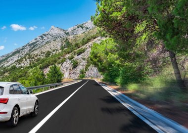 Beyaz araba denize yol boyunca koşar.