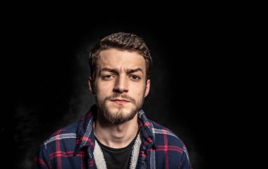 Siyah arka planda sakallı genç adam.