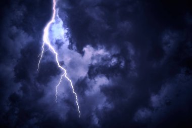 Bulutlu karanlık gökyüzüne yıldırım düşmesi.