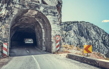 Dağlar arasında karayolu ve tünelin girişi.