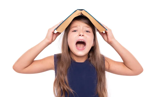 Little girl with an open book on her head is angry. — Stock Photo, Image