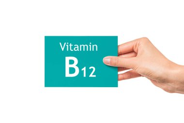 Kadın eli üzerinde B12 vitamini yazan bir kart gösteriyor. B12 vitamini.