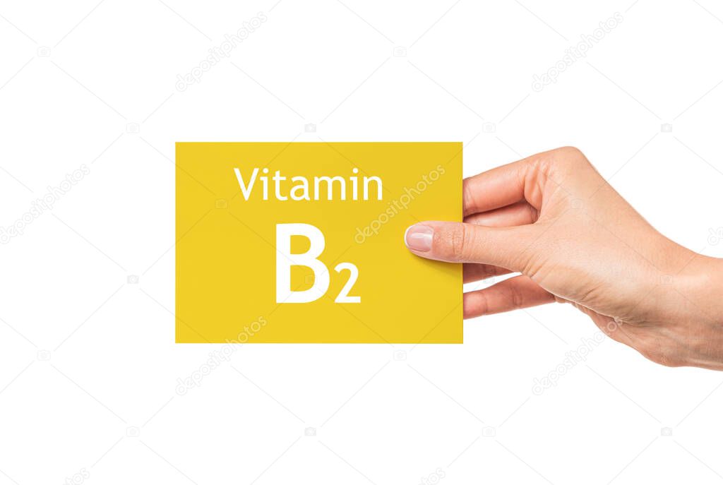 Female hand shows a card with the inscription Vitamin B2. Vitamin B2.