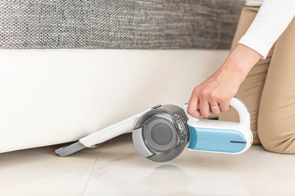 손에 들고 있는 휴대용 진공청소기로 집안의 가구를 청소하는 여자들. — 스톡 사진