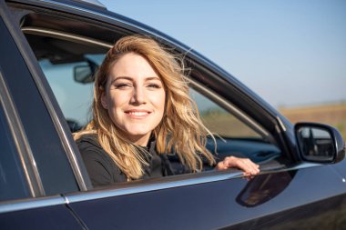 Arabadaki sarışındı. Çekici bir kadın araba kullanıyor..