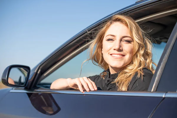 Blondýna v autě. Atraktivní žena řídí auto. — Stock fotografie