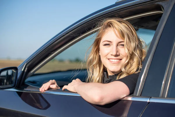 Rubia en el coche. Mujer atractiva conduce un coche. — Foto de Stock