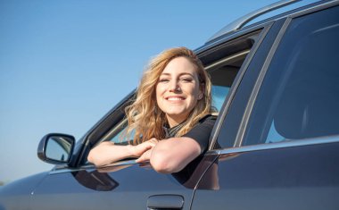 Arabadaki sarışındı. Çekici bir kadın araba kullanıyor..