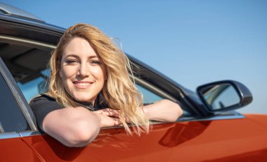 Arabadaki sarışındı. Çekici bir kadın araba kullanıyor..