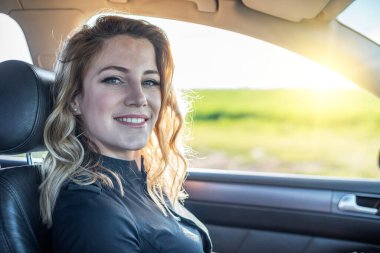 Arabadaki sarışındı. Çekici bir kadın araba kullanıyor..