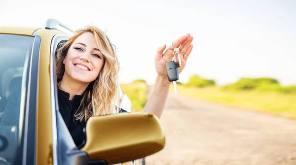 Araba almak ya da kiralamak. Kadın sürücü arabanın anahtarını gösteriyor.. — Stok fotoğraf