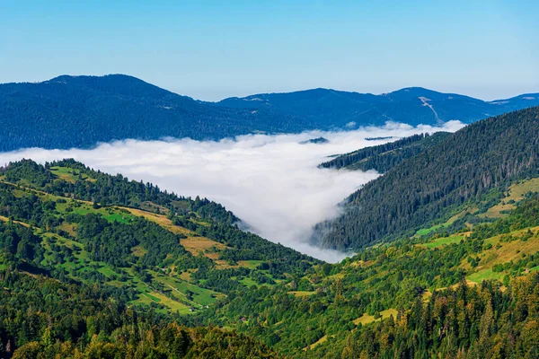 Vista sul paesaggio montano e sulla valle avvolta dalla nebbia. — Foto Stock