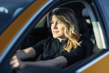 Arabadaki sarışındı. Çekici bir kadın araba kullanıyor..