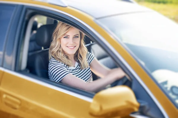 Blondýna v autě. Atraktivní žena řídí auto. — Stock fotografie