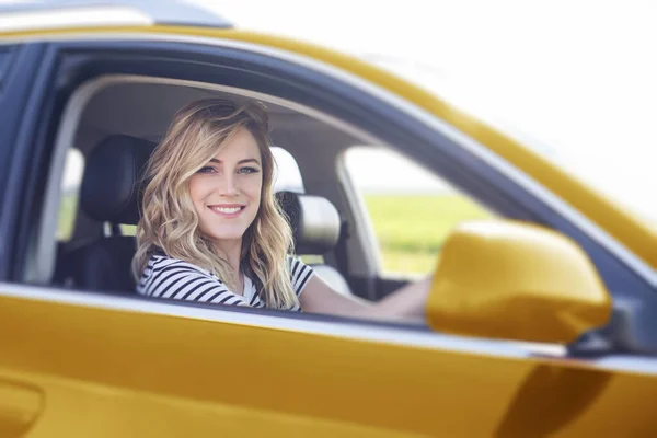 Rubia en el coche. Mujer atractiva conduce un coche. —  Fotos de Stock