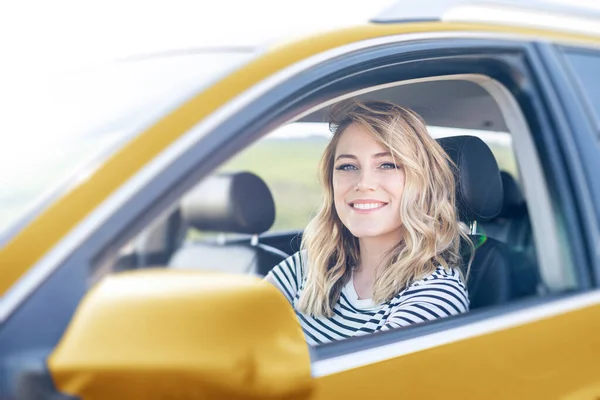 Blondýna v autě. Atraktivní žena řídí auto. — Stock fotografie