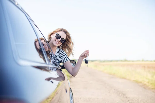Compra ou aluguer de automóveis. A mulher motorista mostra a chave do carro. — Fotografia de Stock