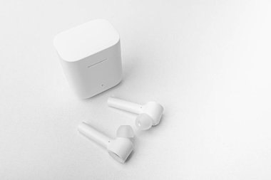 Beyaz arka planda kablosuz kulaklık. Küçük kulaklıklar.