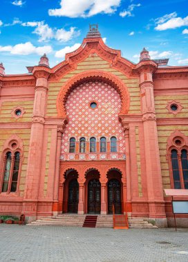 Tarihi Sinagog 'un ön görüntüsü, canlı kırmızı ve sarı tuğla cephesini süsleyen