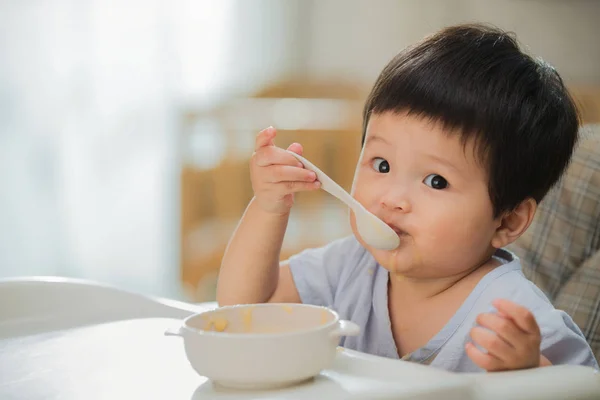 Hermoso Niño Pequeño Comiendo Con Cuchara Mirando Cámara Casa —  Fotos de Stock