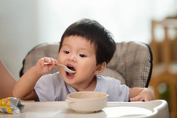Sevimli Asya Toddler Tutmak Kaşık Yeme Evde — Stok fotoğraf